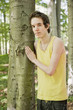 Young man standing by a tree in the woods Young man standing by a tree in the woods