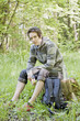 Young man resting during a trek in the woods Young man resting during a trek in the woods