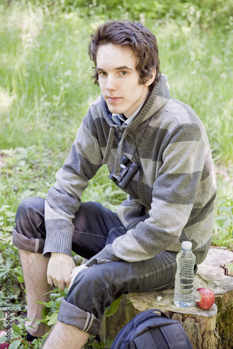 Photo: Young man resting during a trek in the woods Young man resting during a trek in the woods