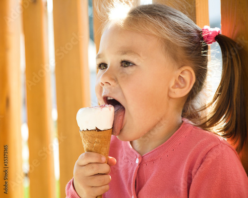 Photo: Little girl is eating ice-cream Little girl is eating ice-cream