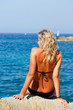 Ragazza che prende il sole sugli scogli
