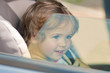 kid looking across a window pane smiling