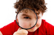 Boy looking through magnifying glass isolated on white