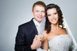 Just married groom and bride on gray