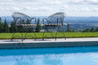Wrought iron patio chairs beside a swimming pool