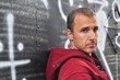 Serious Caucasian man against a graffiti wall