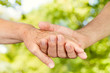 Closeup of old people hands holding together outdoor