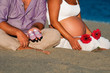 Photo: Pareja esperando un bebé sentada en la playa Pareja esperando un bebé sentada en la playa