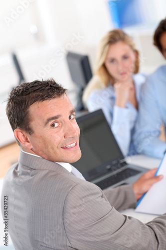 Photo: Couple with real-estate agent in office Couple with real-estate agent in office