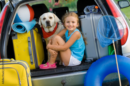 Foto: Girl with dog ready for travel for summer vacation Girl with dog ready for travel for summer vacation