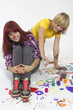 Two young joyful girls draw with motley paints