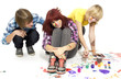 Joyful teenagers have a good time drawing with motley paints