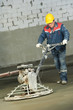 Worker trowelling and finishing of concrete Worker trowelling and finishing of concrete