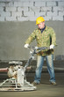 Worker trowelling and finishing of concrete Worker trowelling and finishing of concrete