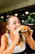 Foto: Frau im Restaurant isst Hamburger Frau im Restaurant isst Hamburger