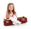 Photo: Happy small child sitting in a suitcase. Travel concept. Isolate Happy small child sitting in a suitcase. Travel concept. Isolate