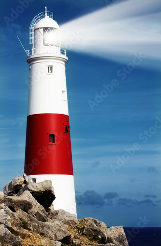 Foto: Lighthouse on rocks with lightbeam on Portland Lighthouse on rocks with lightbeam on Portland
