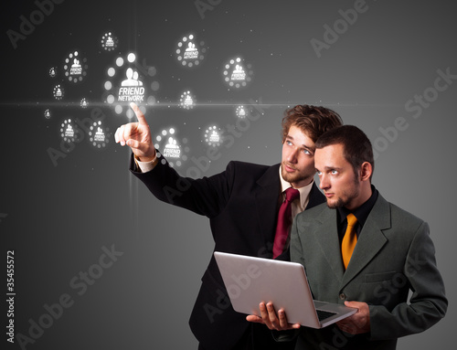 Photo: Businessman pressing modern social type of icons Businessman pressing modern social type of icons