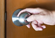 Hand locking the door of his home.
