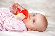 baby girl laying witn baby bottle