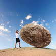 Businesswoman rolling a giant stone