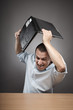 Photo: Angry businessman smashing his laptop Angry businessman smashing his laptop