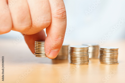 Photo: Businessman hand reaching for pennies Businessman hand reaching for pennies