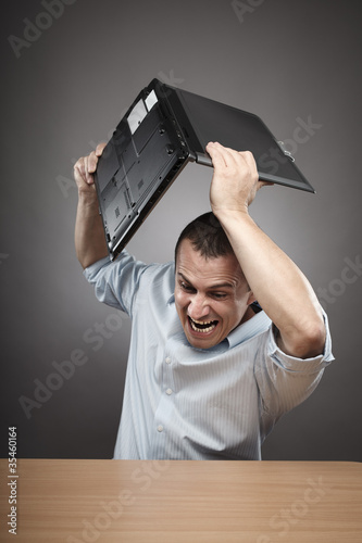 Photo: Angry businessman smashing his laptop Angry businessman smashing his laptop