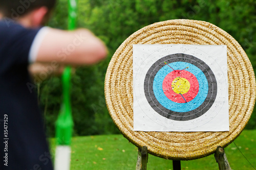Photo: An archer with bow takes aim at target An archer with bow takes aim at target