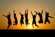 silhouette of friends jumping in sunset