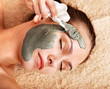 Young woman having clay body mask. Young woman having clay body mask.