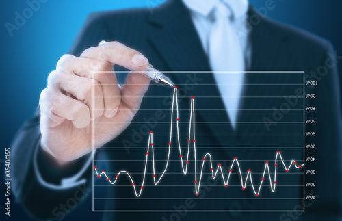 Foto: businessman writing graph of stock market businessman writing graph of stock market