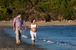 Photo: Couple expecting a baby walking on the beach Couple expecting a baby walking on the beach
