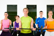 Fitness people with barbell in gym