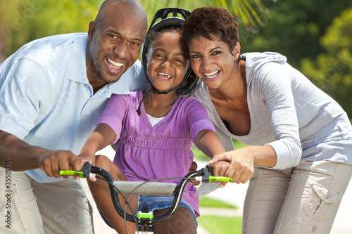Photo: African American Family WIth Girl Riding Bike & Happy Parents African American Family WIth Girl Riding Bike & Happy Parents