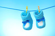 baby booties from a rope on a blue background baby booties from a rope on a blue background