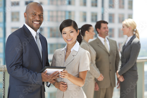 Photo: Interracial Men & Women Business Team With Tablet Computer Interracial Men & Women Business Team With Tablet Computer