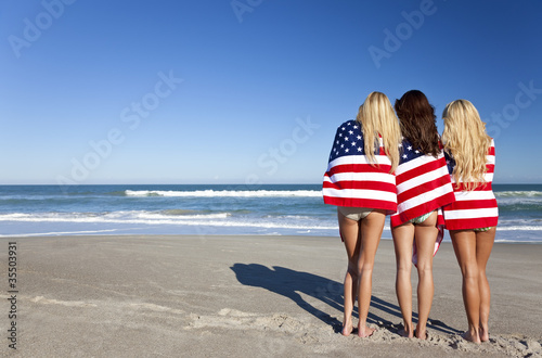 Photo: Three Young Women Wrapped in American Flags on a Beach Three Young Women Wrapped in American Flags on a Beach