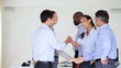 Business colleagues standing together in office with two