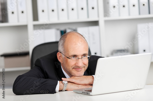 Foto: entspannter geschäftsmann liest am laptop entspannter geschäftsmann liest am laptop