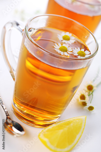 Photo: cup of herbal tea with chamomile flowers and lemon cup of herbal tea with chamomile flowers and lemon