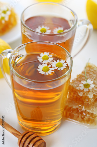 Photo: cup of herbal tea with chamomile flowers and honey -healthy life cup of herbal tea with chamomile flowers and honey -healthy life