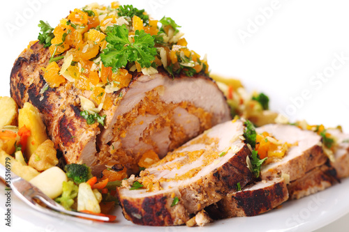 Photo: Stuffed pork roast with dried apricots and nuts on white backgro Stuffed pork roast with dried apricots and nuts on white backgro