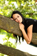Junge Frau sitzt im Baum