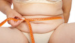 Fat woman measuring her stomach