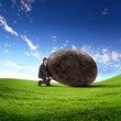 Businessman rolling a giant stone