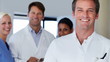 Portrait of doctor smiling with colleagues in background