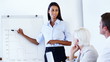 Mixed race woman explaining graph to team at meeting