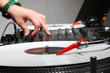 Hands of a DJ playing music from vinyl