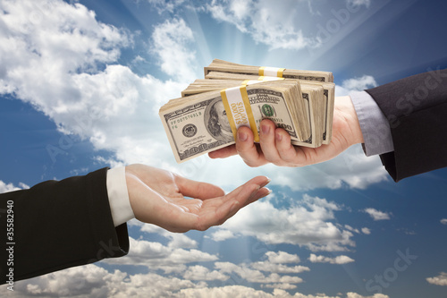 Photo: Handing Over Cash with Dramatic Clouds and Sky Handing Over Cash with Dramatic Clouds and Sky
